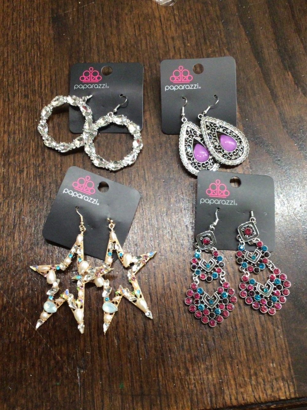Four pair of brand new paparazzi earrings still on the original tab.